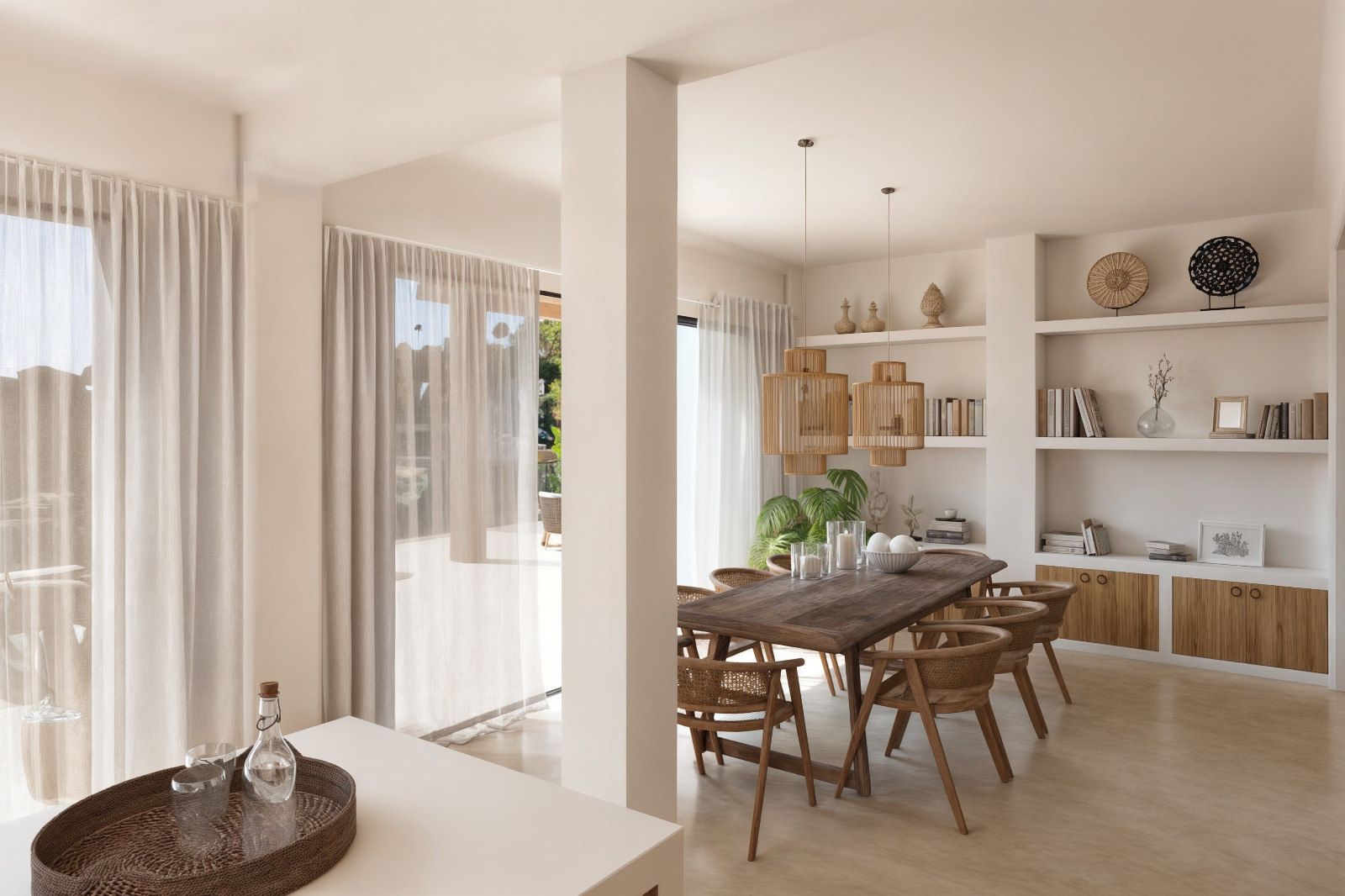 Eethoek in Ibizastijl met massief houten tafel, rotan stoelen en geïntegreerde wandplanken. Grote raampartijen met lichte gordijnen bieden toegang tot het aangrenzende terras.