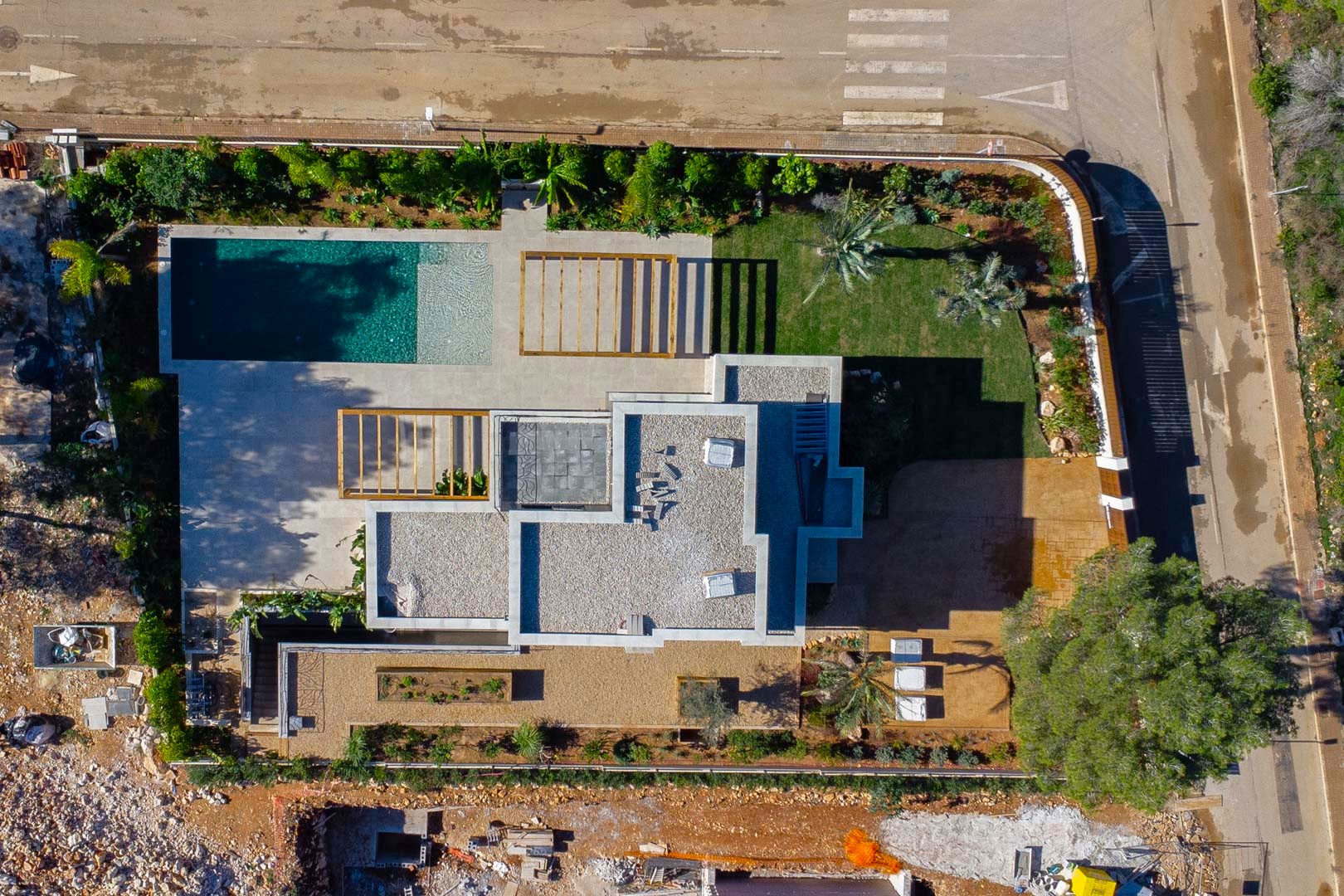 Bovenaanzicht van de villa met de indeling van het perceel, het zwembad in Bali-stijl, houten pergola's en de aangelegde mediterrane tuin.
