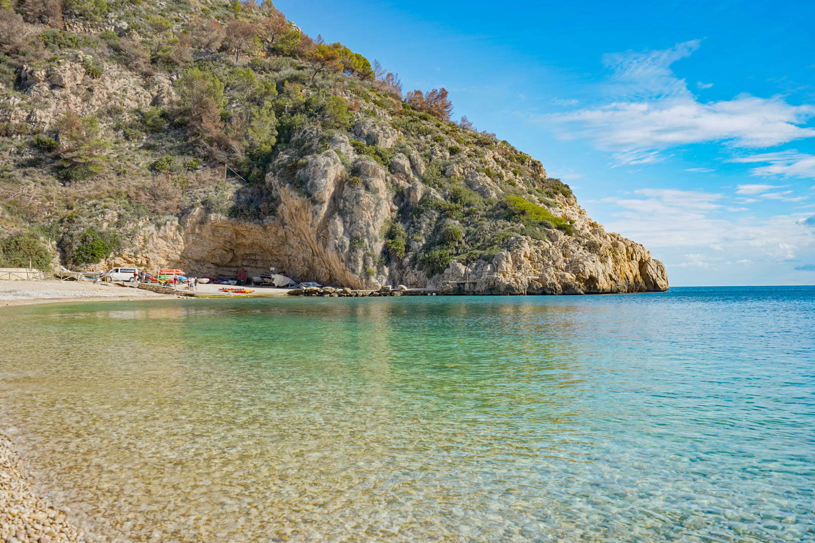 Uitzicht op het strand van Granadella in Jávea, met helder turquoise water en kalkstenen kliffen, gelegen op korte afstand van de villa.