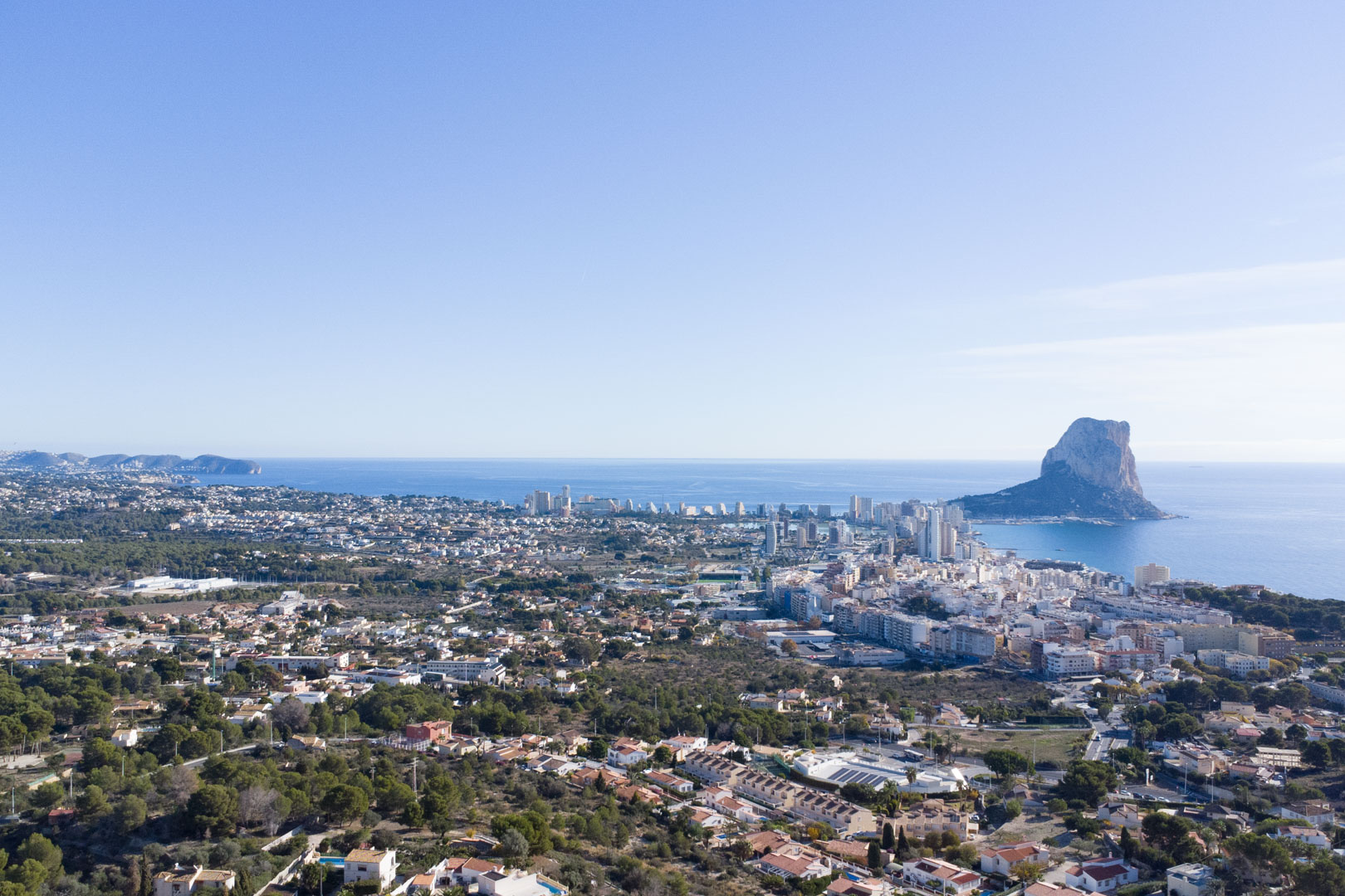 Panoramisch luchtfoto van de kustlijn van Calpe, met de Peñón de Ifach, de skyline van de stad en de uitgestrekte Middellandse Zee.