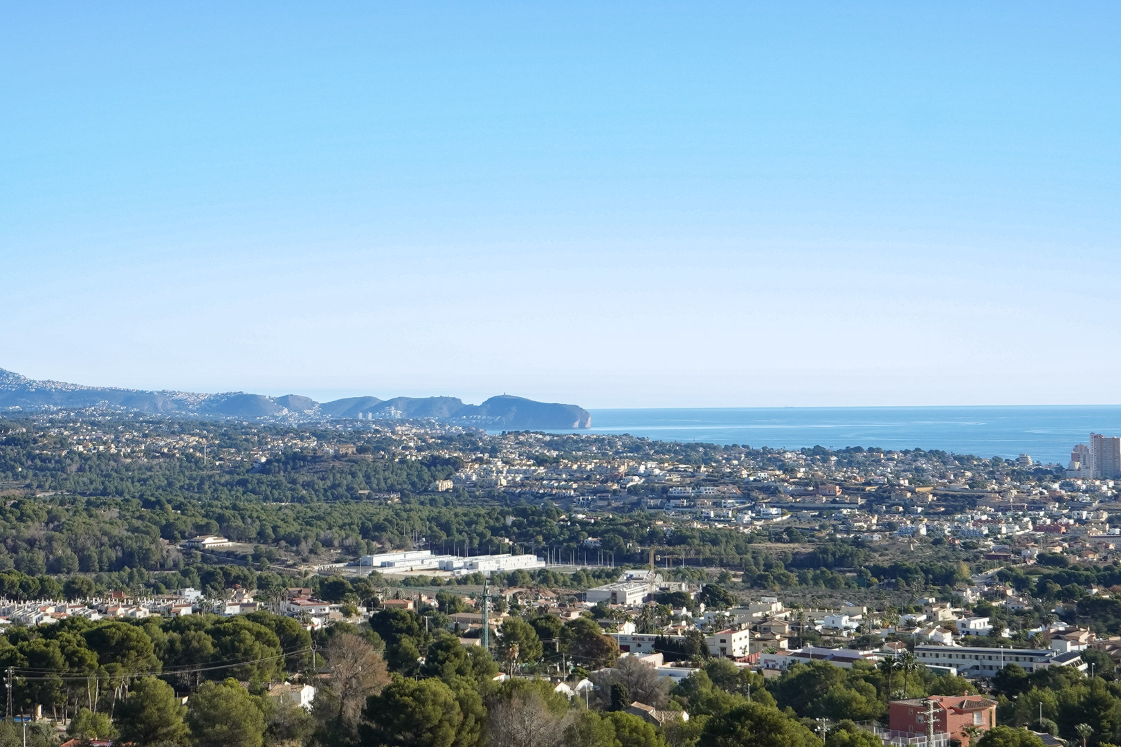 Verhoogd panoramisch uitzicht op de Middellandse Zeekust en Cap d’Or, uitkijkend over de woonwijken en dichte dennenbossen van Calpe.