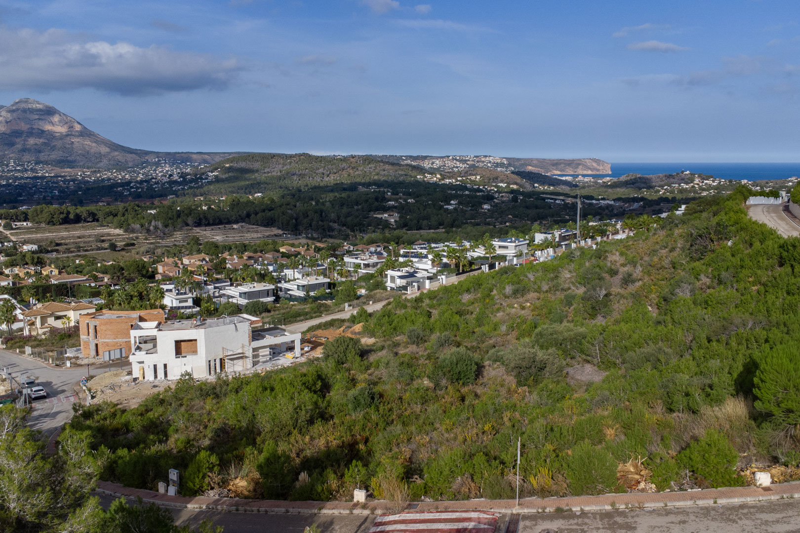 Verhoogd uitzicht op het perceel in Monte Olímpico, met het Montgó-massief en de Middellandse Zee bij Cabo de San Antonio aan de horizon.