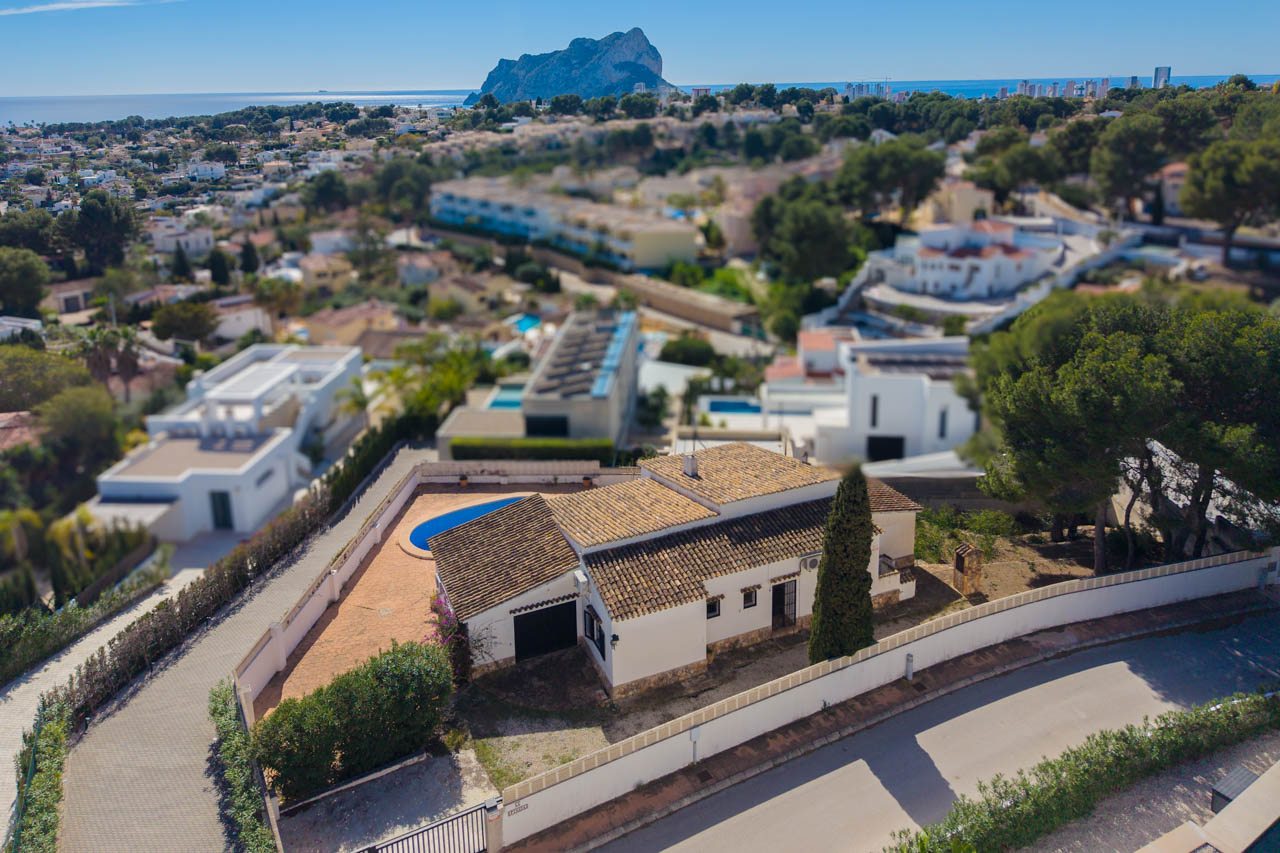 Luchtfoto van de mediterrane villa met pannendak, privézwembad en weids uitzicht over de zee en de iconische Peñón de Ifach in Calpe.