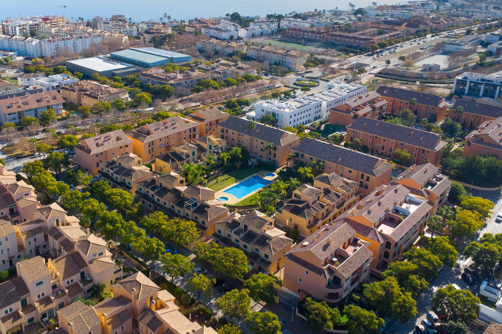 Luchtfoto van het Floridamar-complex in Jávea, met het centrale zwembad, de aangelegde tuinen en de nabijheid van de Middellandse Zee.