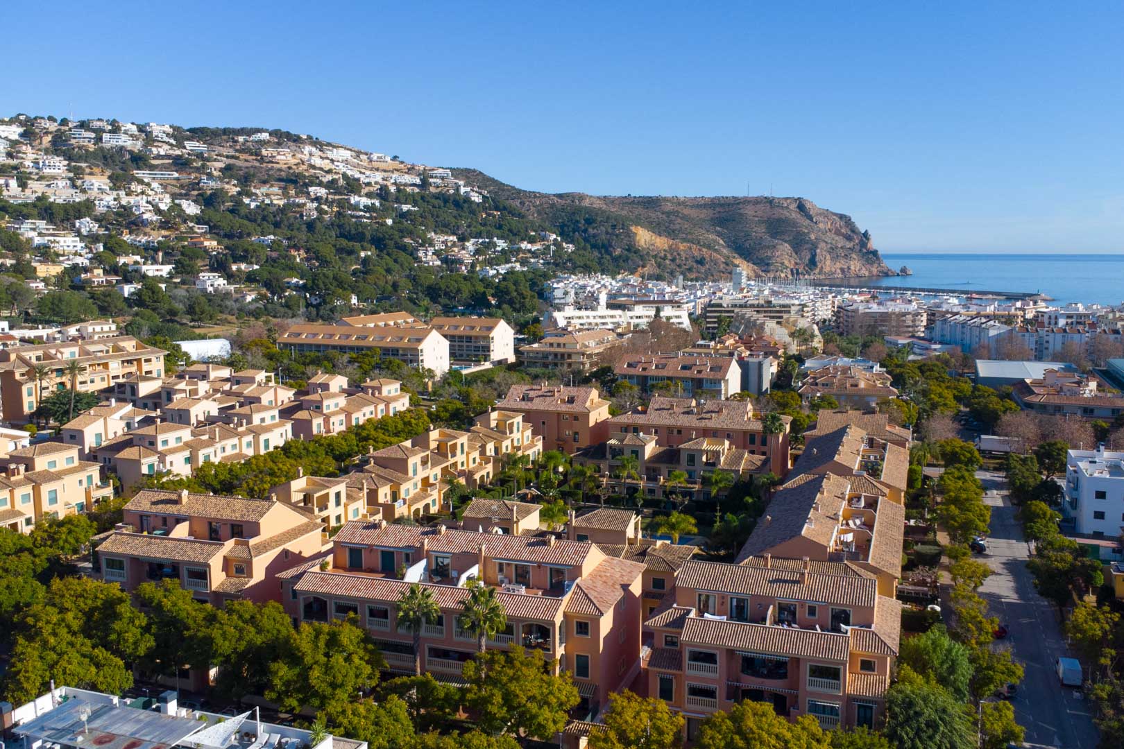 Luchtfoto van het Floridamar-complex in Jávea, met mediterrane architectuur, volgroeide tuinen en de gunstige ligging nabij de haven en de zee.