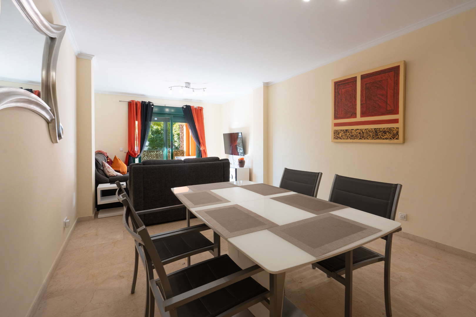 Open woon- en eetkamer met marmeren vloeren, modern meubilair en directe toegang tot het terras via grote glazen schuifdeuren.