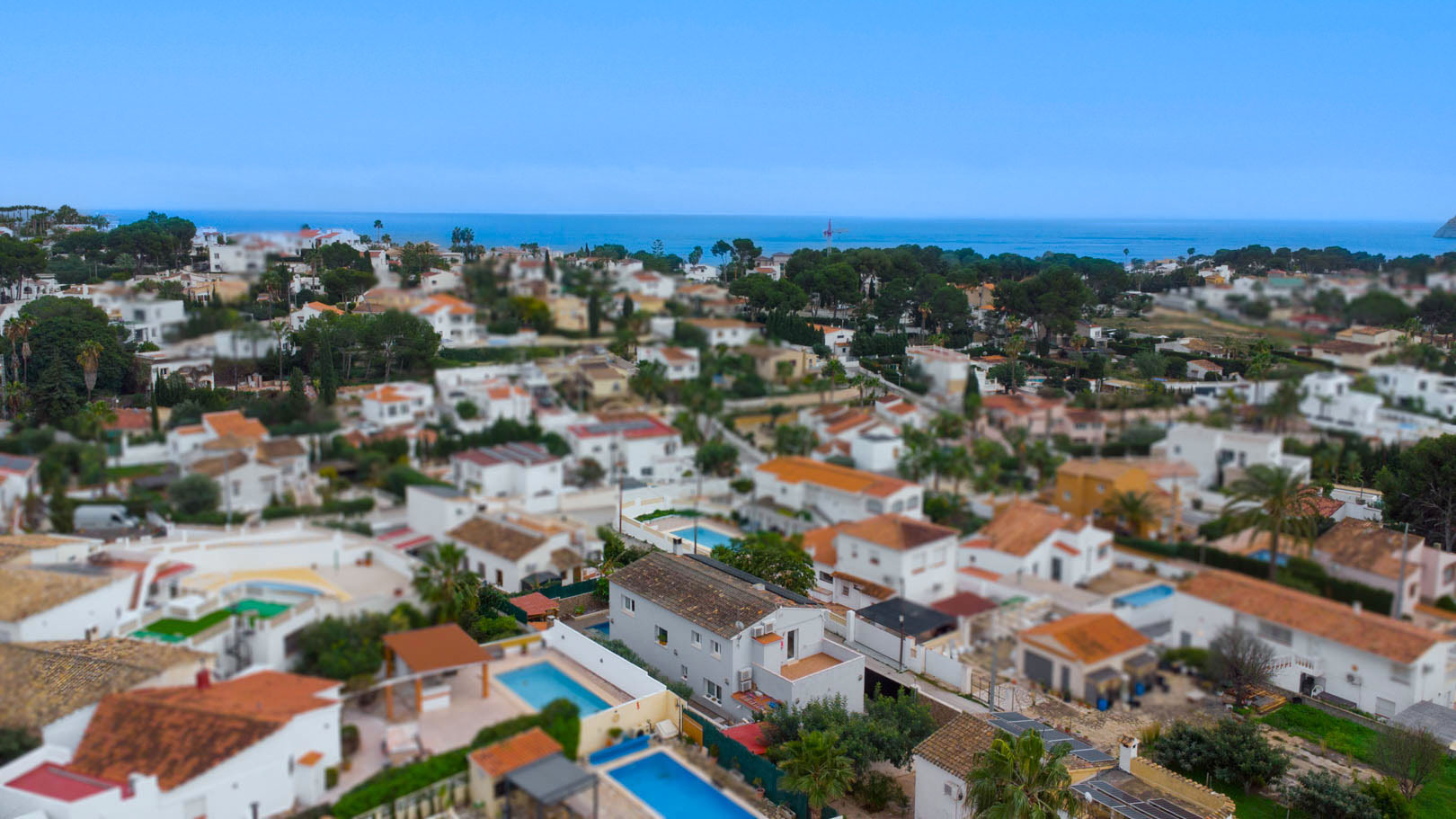 Luchtfoto van de urbanisatie Carrio in Calpe, met de nabijheid van de Middellandse Zee en de indeling van de villa's met privézwembaden.