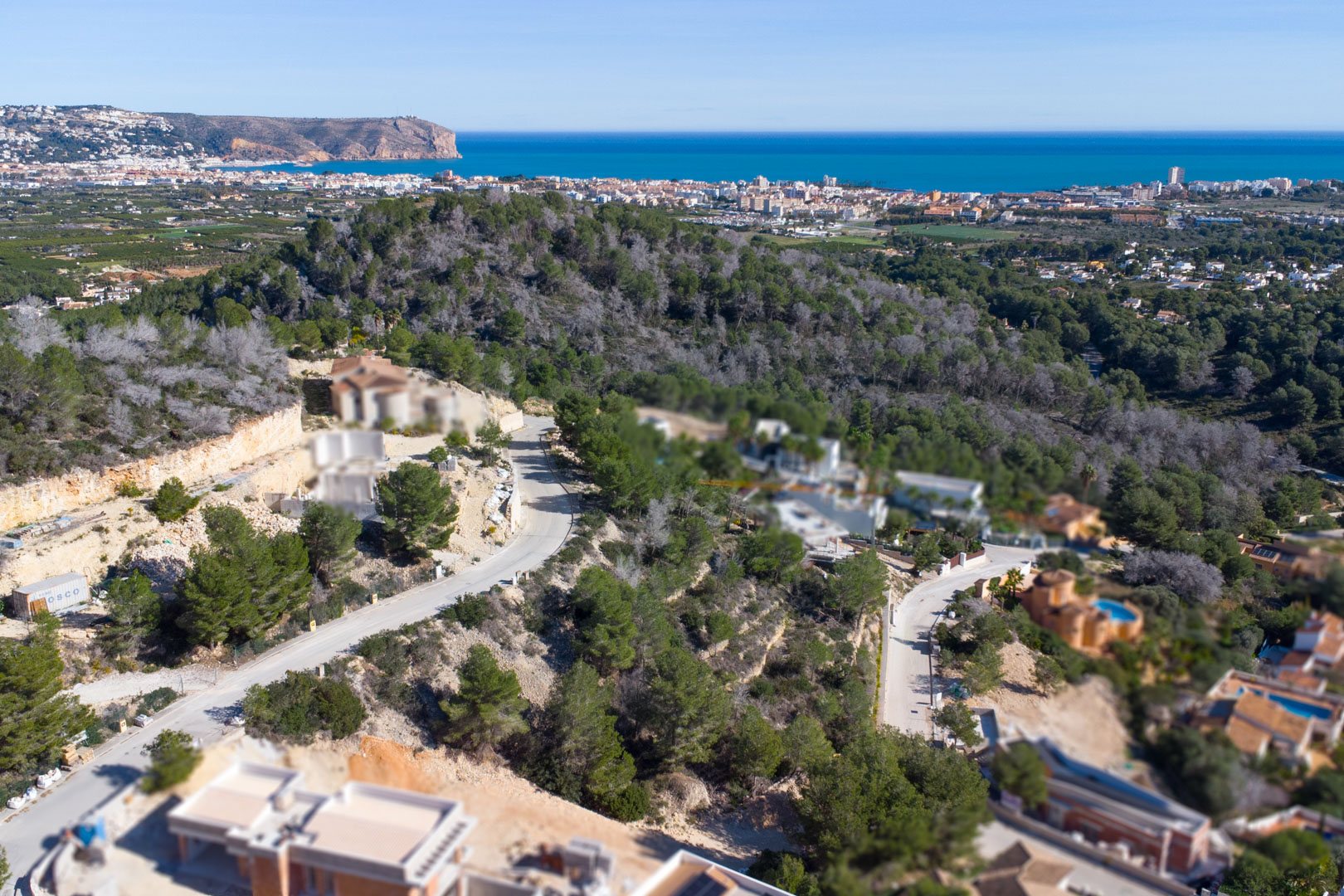 Luchtopname van de wijk Tosalet 5 in Jávea, met bouwrijpe percelen op een heuvelrug en een weids uitzicht over de Middellandse Zee en Cabo de San Antonio.