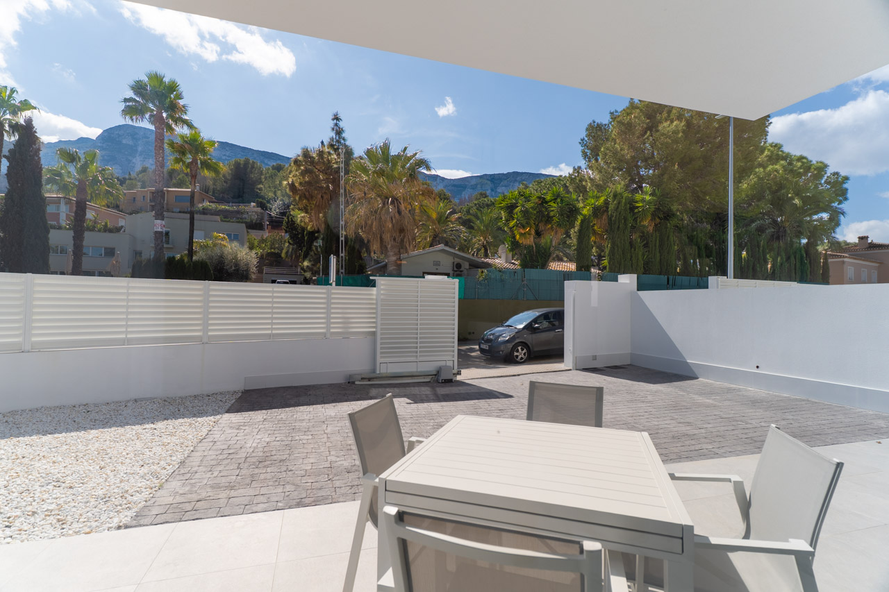 Buitenterras met eethoek en privé parkeerplaats. Het biedt vrij uitzicht op het Montgó-gebergte binnen een moderne en functionele architecturale setting.