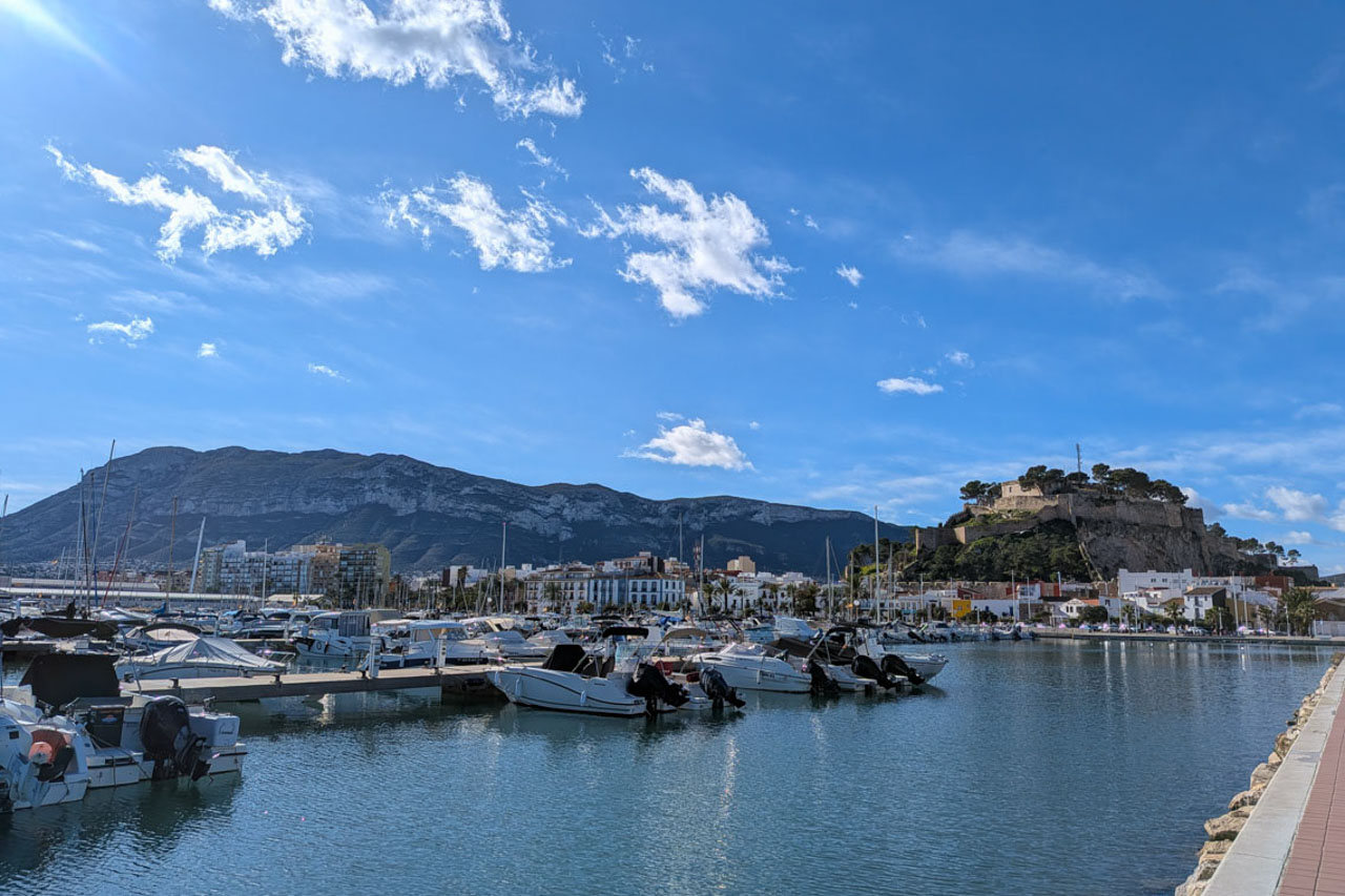 Panoramisch uitzicht op de jachthaven van Dénia met het historische kasteel en het Montgó-gebergte op de achtergrond.