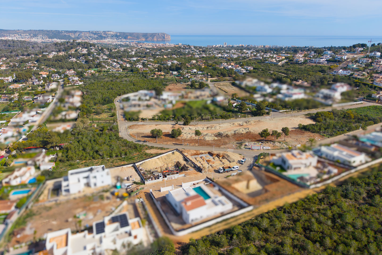 Luchtfoto van het bouwperceel in Valsol, Jávea, met de funderingswerken en een panoramisch uitzicht over de Middellandse Zee en de kustlijn.