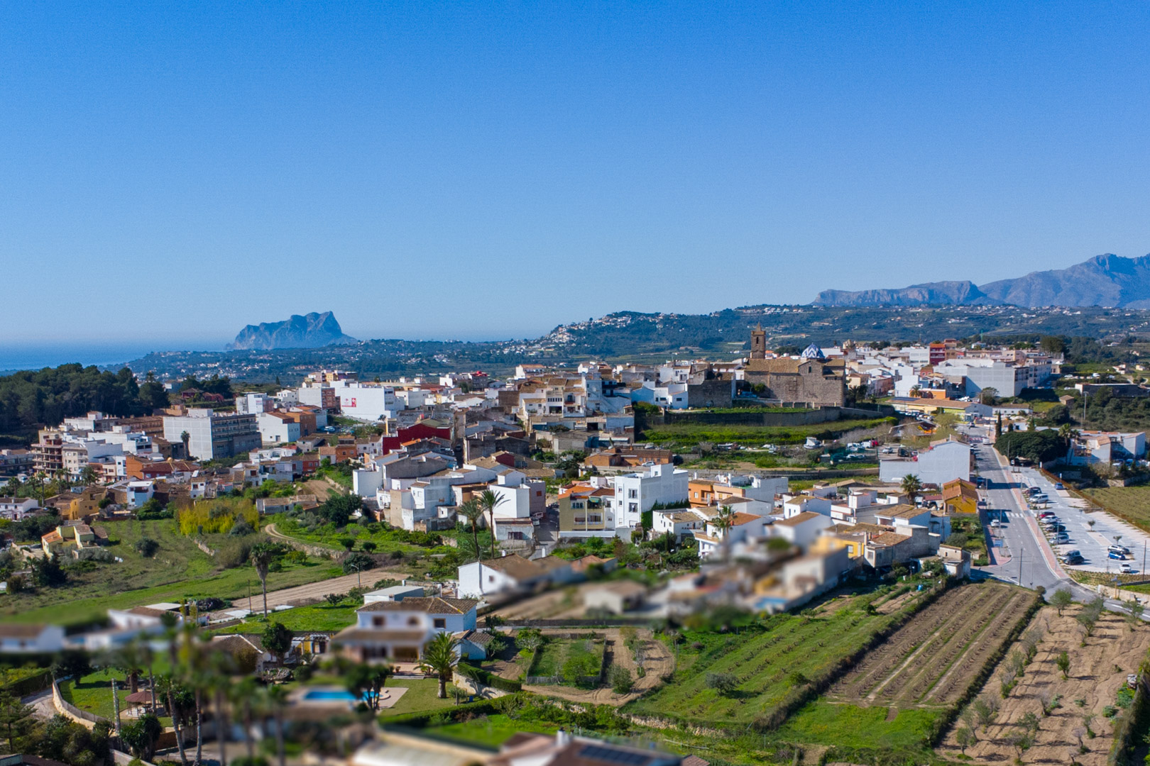 Panoramisch luchtfoto van Benitachell met uitzicht op het historische centrum, de kerk en de Peñón de Ifach aan de Middellandse Zee.