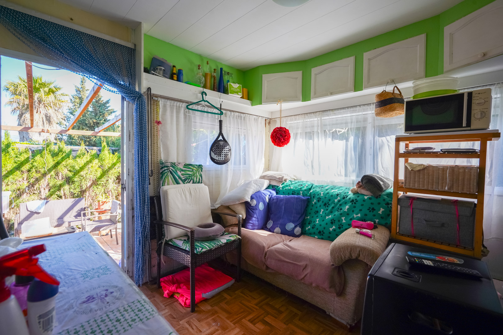 Woonkamer van de prefab woning met parketvloer, veel natuurlijk licht en directe toegang tot het buitenterras met uitzicht op de tuin.