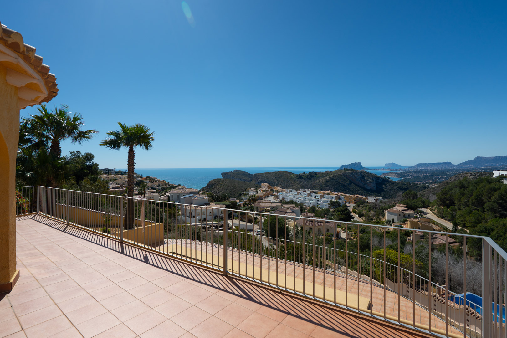 Ruim zonneterras met metalen balustrade en panoramisch uitzicht over de Middellandse Zee, de Peñón de Ifach en de kustlijn van Moraira en Calpe.