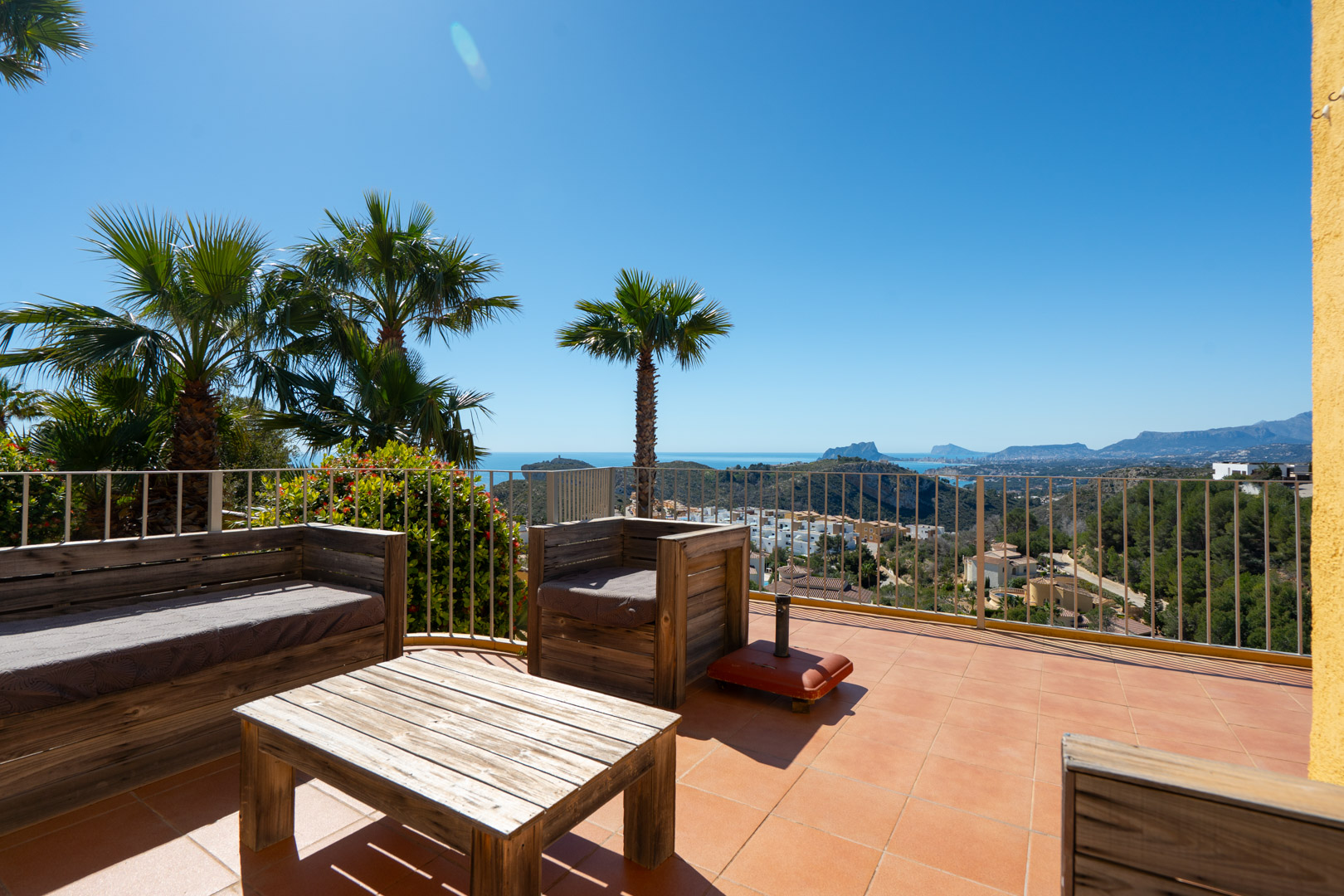 Solariumterras met rustieke houten meubelen en panoramisch uitzicht op de Middellandse Zee, de Peñón de Ifach en de kust van Calpe.