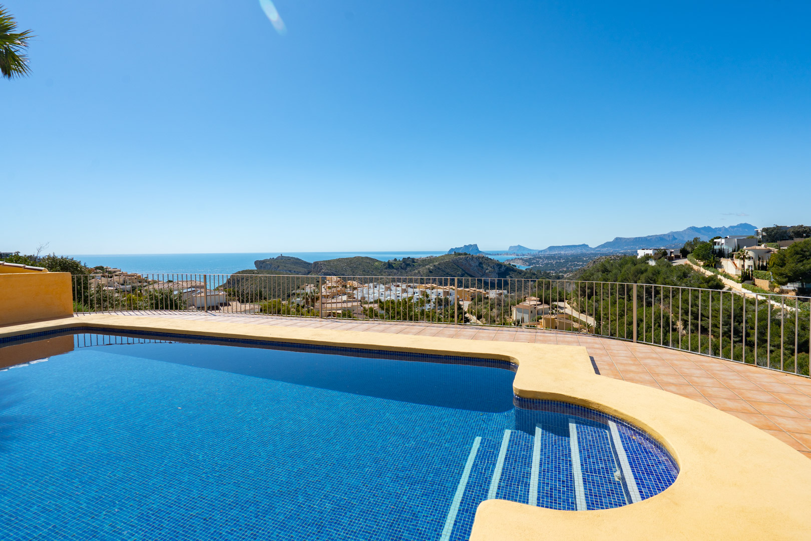 Terras met blauw betegeld zwembad en panoramisch uitzicht op de Middellandse Zee, de kustlijn van Calpe en het Bernia-gebergte.