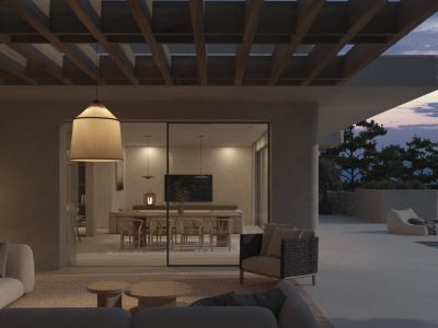 Sfeervolle buitenwoonkamer onder houten pergola met moderne banken en hanglamp, grenzend aan een elegante eetruimte met berguitzicht bij zonsondergang.
