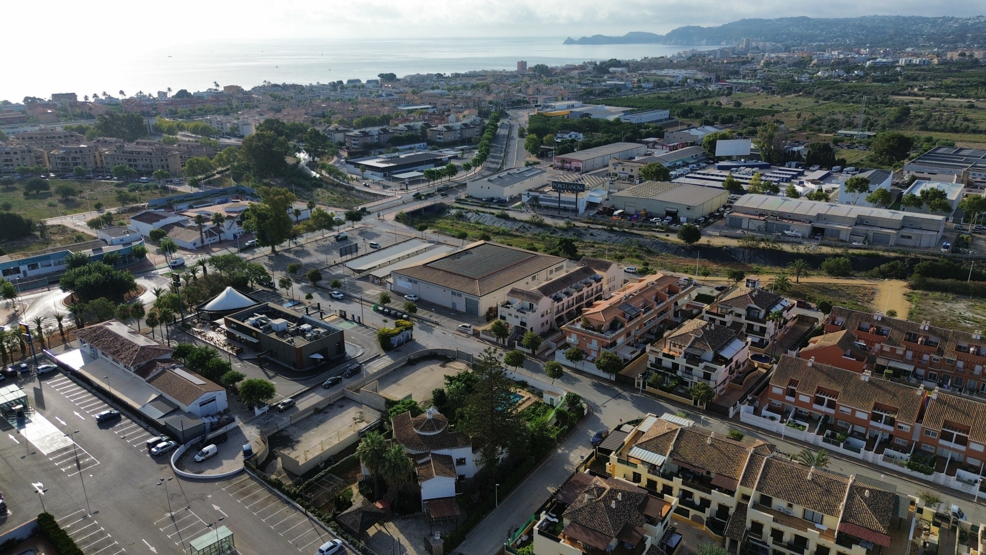 Luchtfoto van Jávea met residentiële en commerciële gebouwen en de Middellandse Zee op de achtergrond.