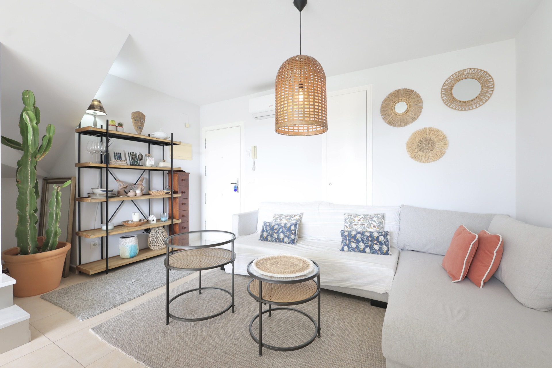 Lichte woonkamer met houten rek, modulaire bank en design bijzettafels.