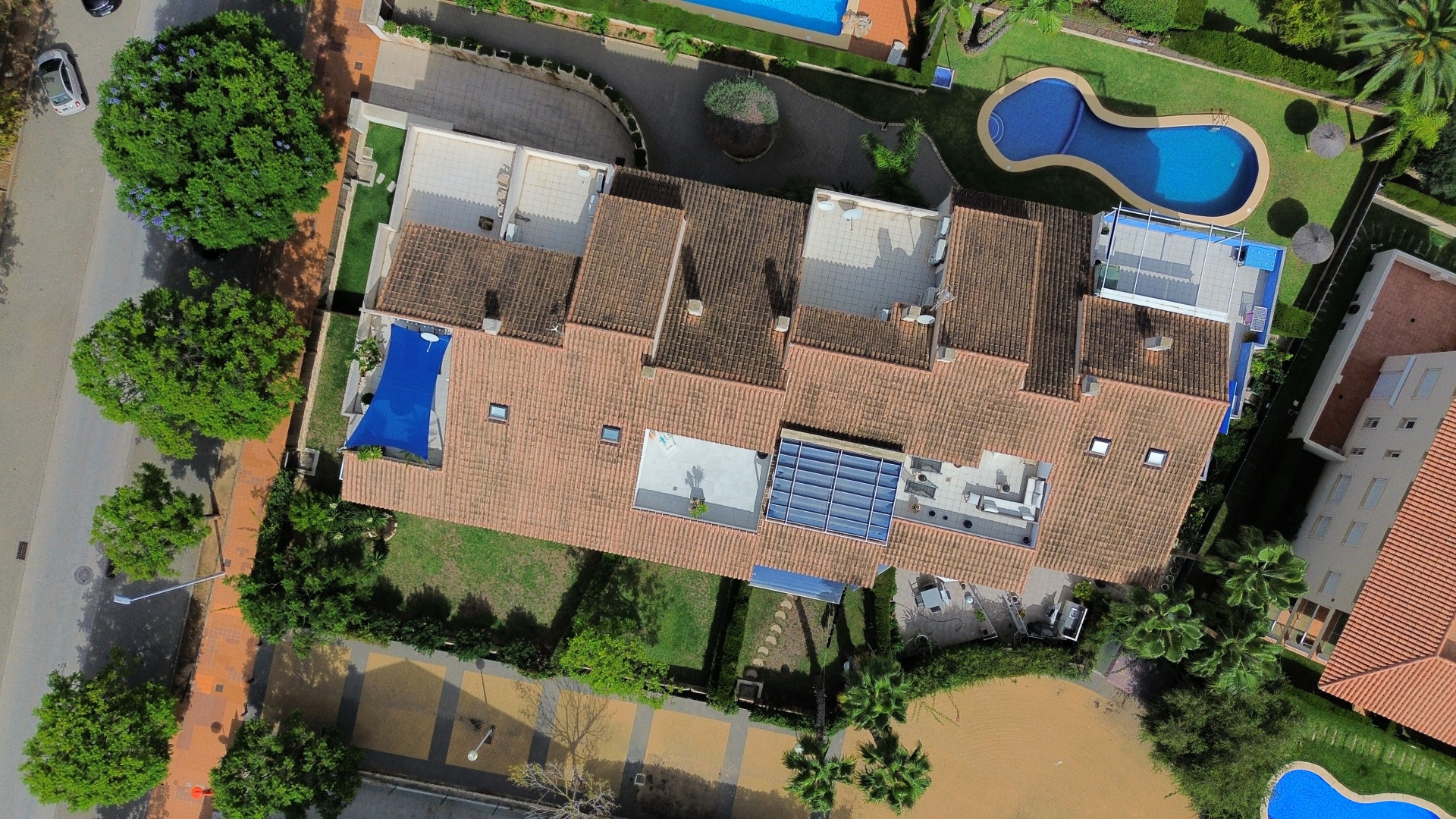 Luchtfoto van het duplex penthouse met terrassen, zwembad en weelderige tuinen.