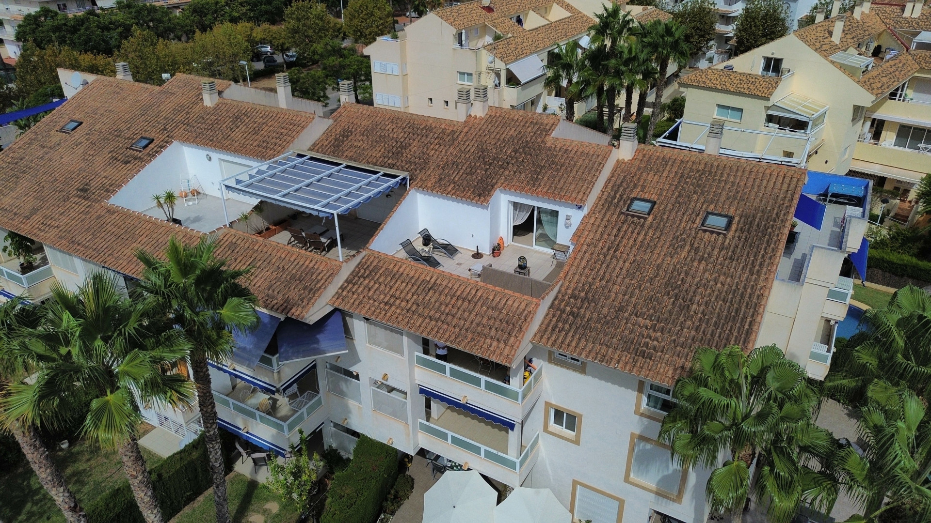 Luchtfoto van het duplex penthouse met zonneterras, luifel en terracotta dakpannen in Jávea.