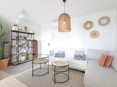 Lichte woonkamer met houten rek, modulaire bank en design bijzettafels.