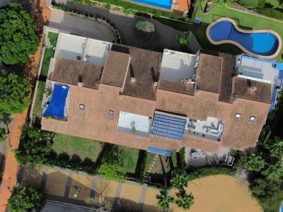 Luchtfoto van het duplex penthouse met terrassen, zwembad en weelderige tuinen.
