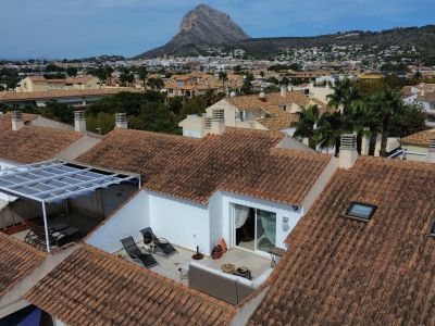 Luchtfoto van het solariumterras met luifel en tuinmeubilair, omgeven door pannendaken.