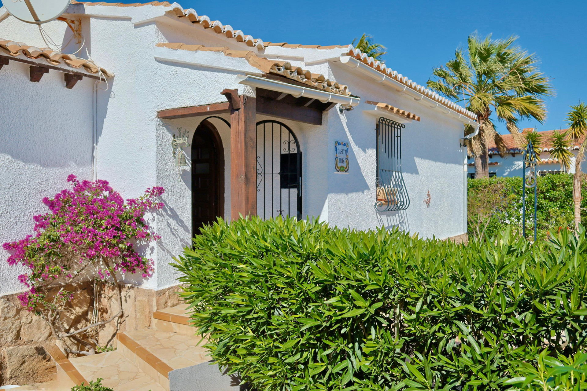 Mediterrane villa gevel met bougainville en houten details.