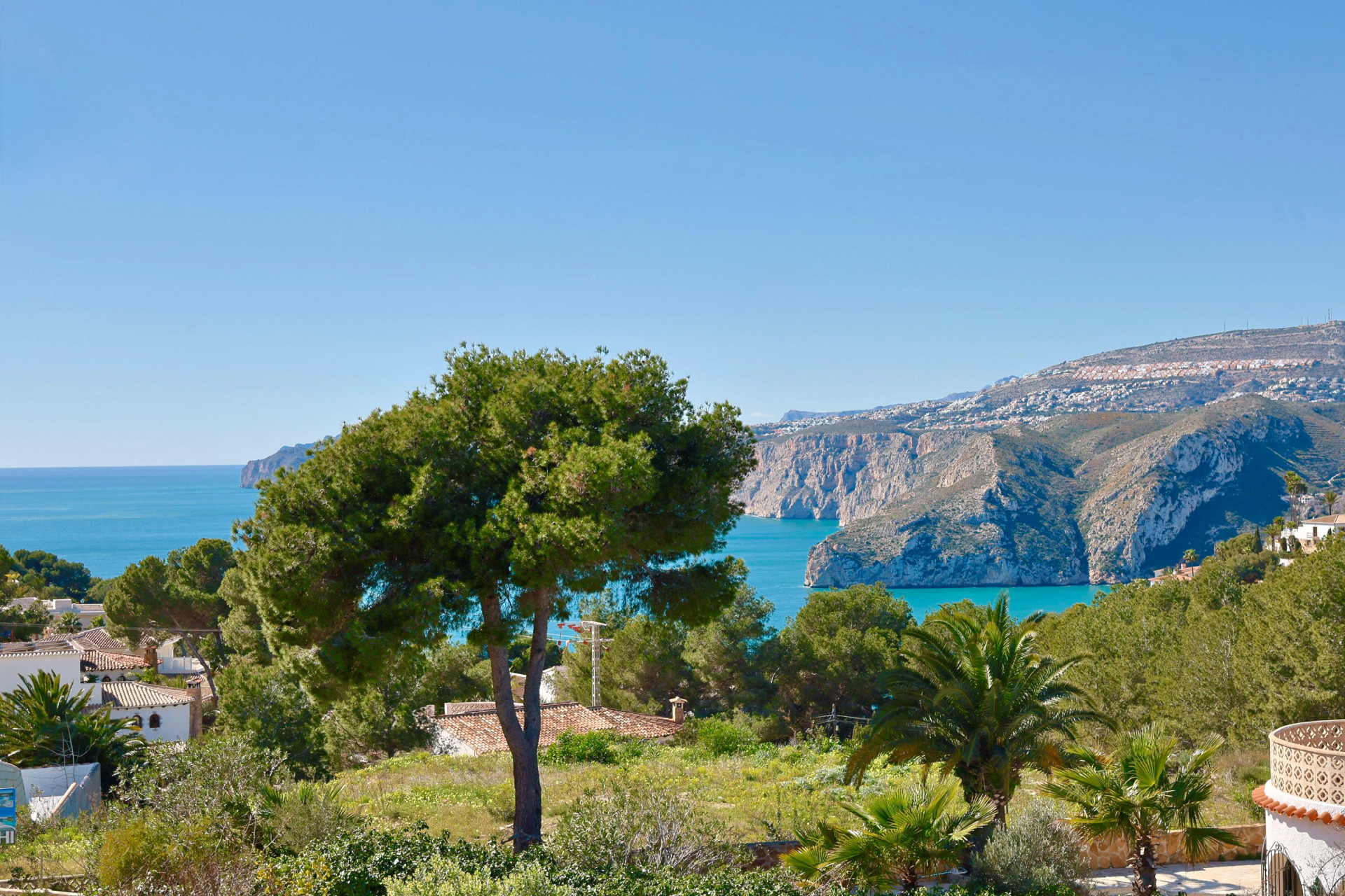 Panoramisch uitzicht op Jávea met weelderig groen en de Middellandse Zee op de achtergrond.
