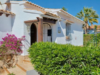 Mediterrane villa gevel met bougainville en houten details.