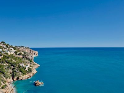 Panoramisch uitzicht op de rotsachtige kustlijn van Jávea en de blauwe Middellandse Zee.