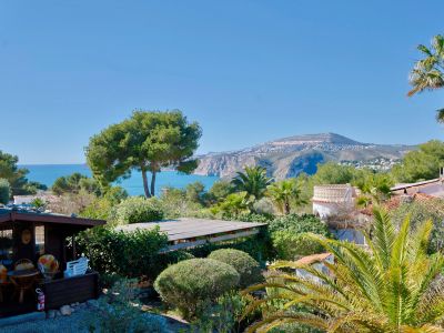 Panoramisch uitzicht op Jávea met houten hut en weelderig groen.