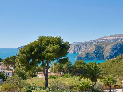 Panoramisch uitzicht op Jávea met weelderig groen en de Middellandse Zee op de achtergrond.