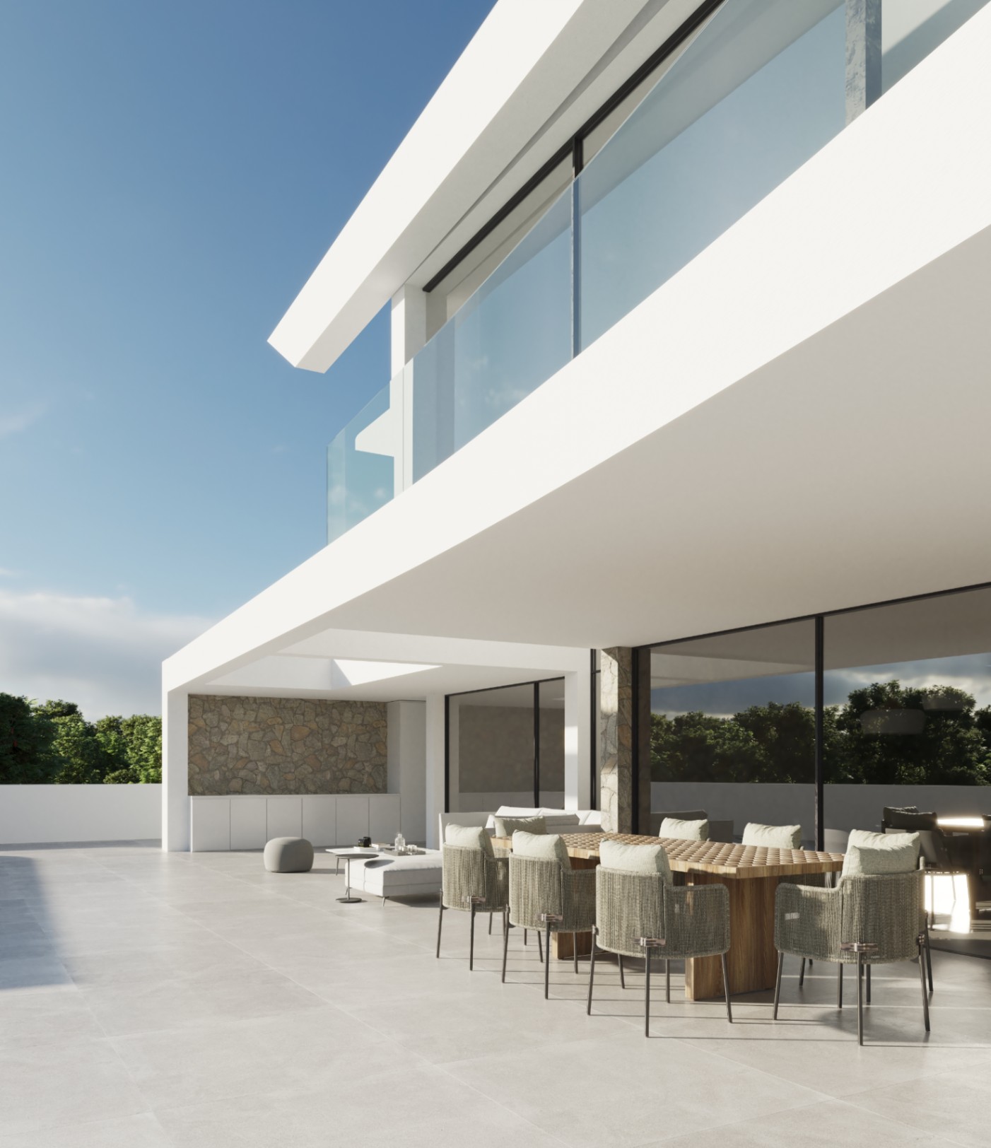 Buitenterras met houten eettafel en gevlochten stoelen onder een minimalistische witte overspanning, afgewerkt met natuurstenen muren en glazen balustrades.