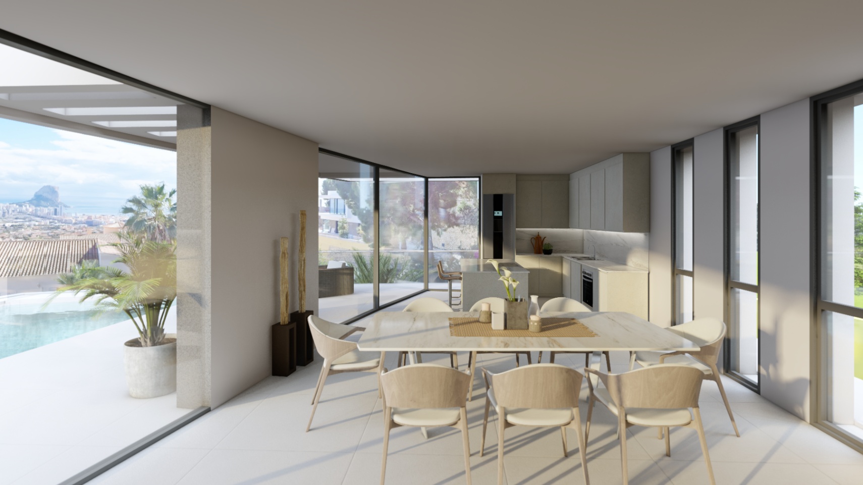 Open eetruimte met minimalistische keuken en glazen puien die uitkijken op het terras met infinity pool en het panoramische zicht op de Peñón de Ifach.