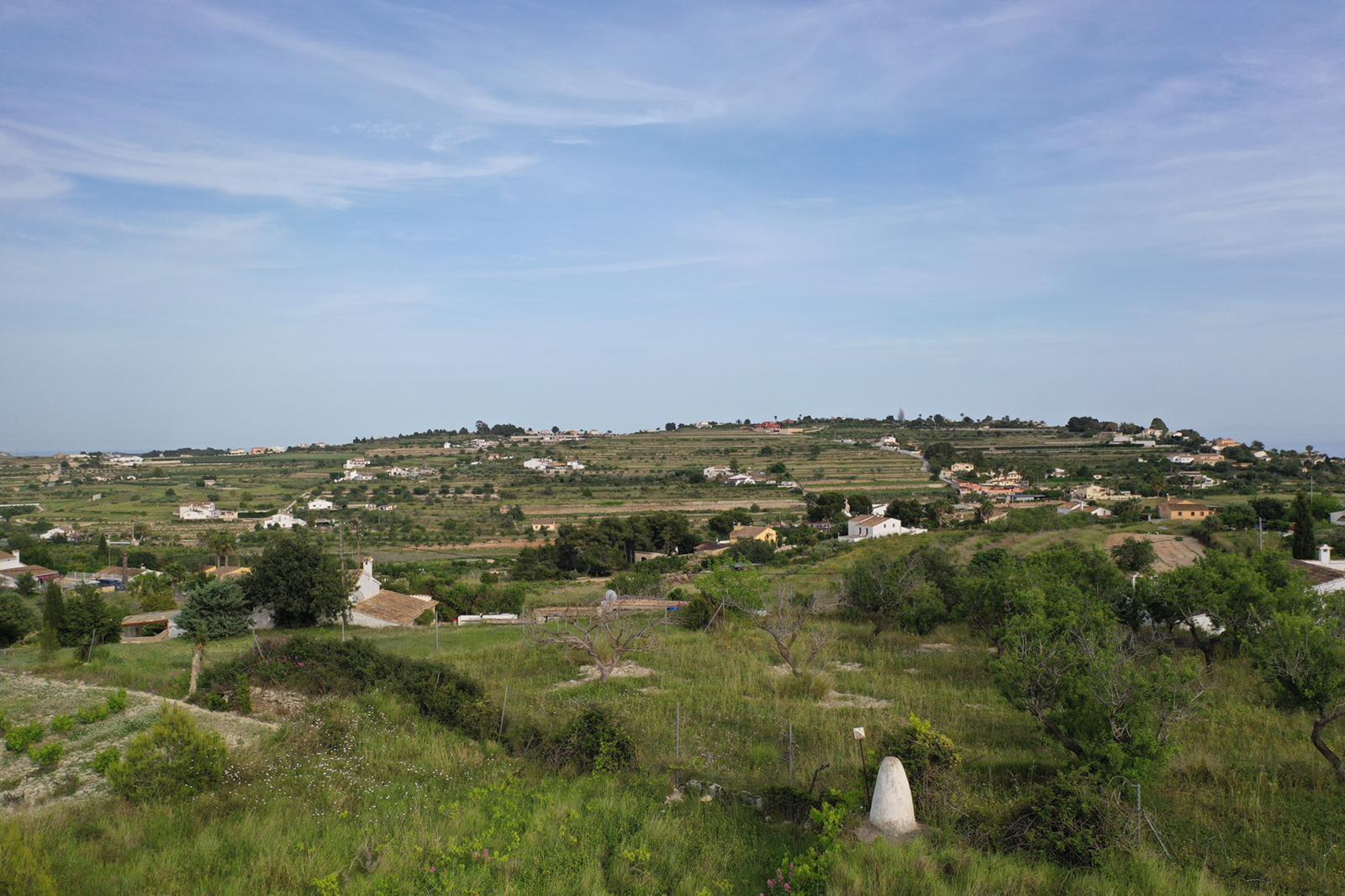 Panoramisch uitzicht op de natuurlijke omgeving met terrasvormige heuvels en mediterrane vegetatie onder een heldere hemel.