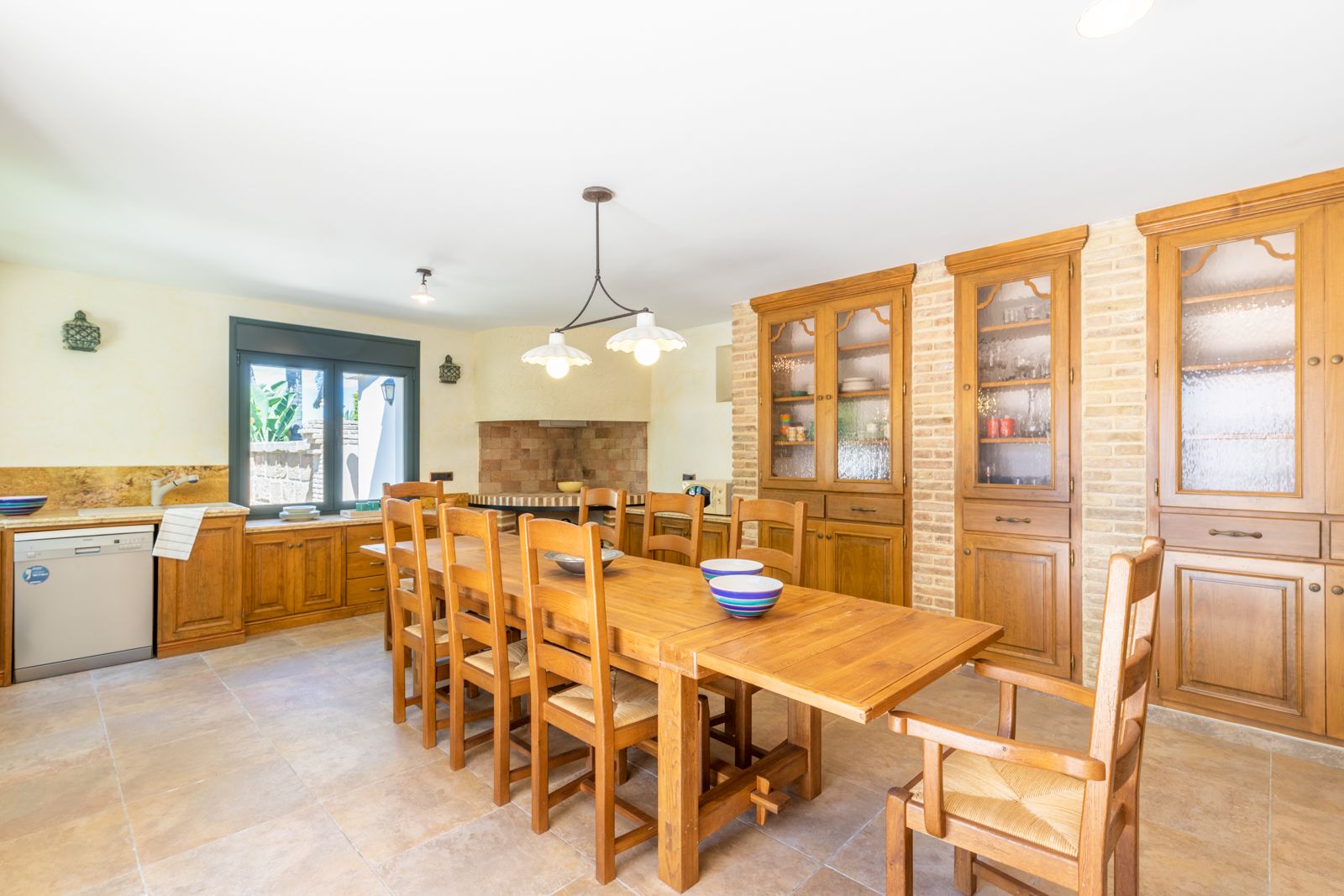 Eetkamer met massief houten tafel en ingebouwde buffetkast met bakstenen.