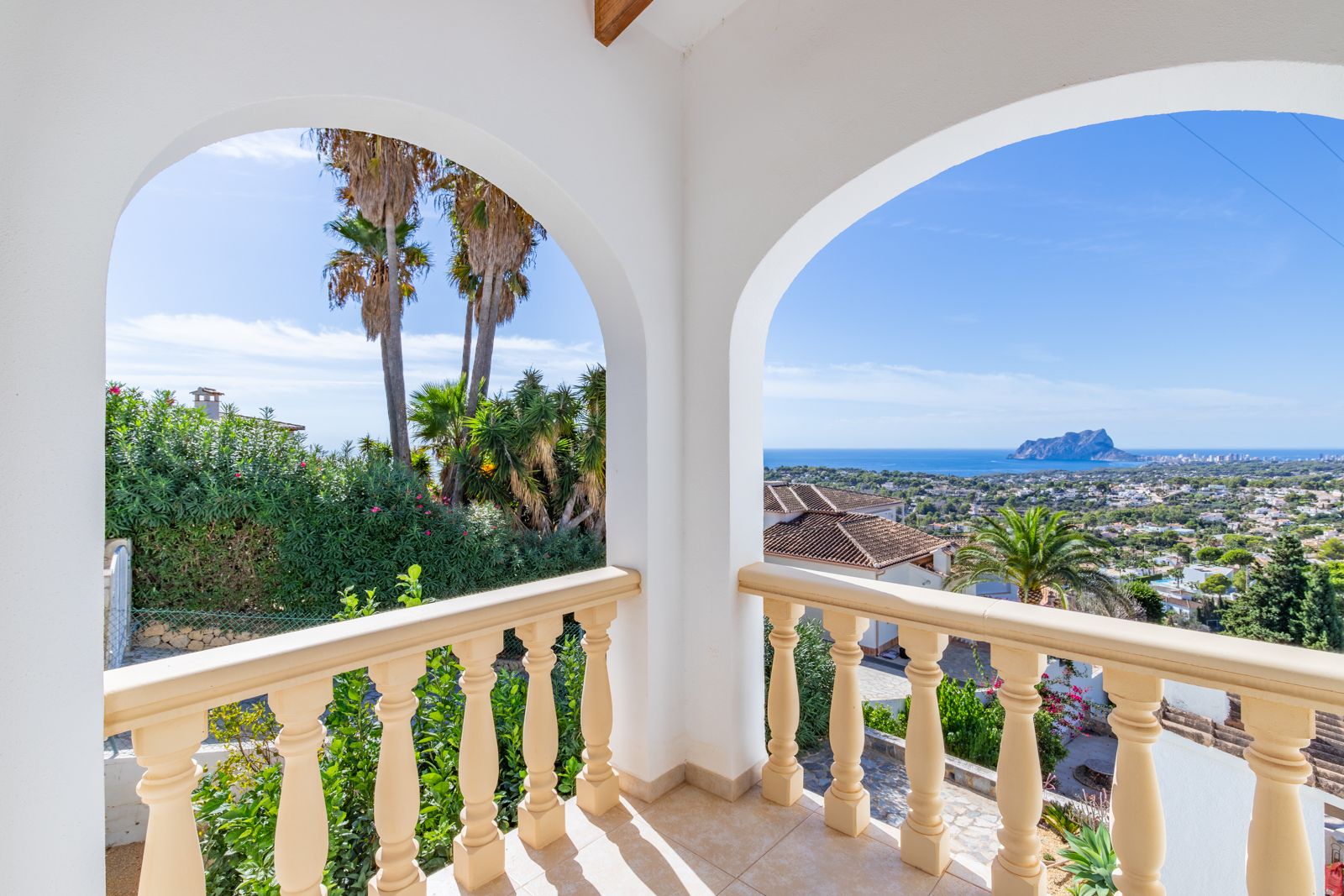 Overdekt terras met witte bogen en een klassieke balustrade, met panoramisch uitzicht op de Middellandse Zee en de Peñón de Ifach.