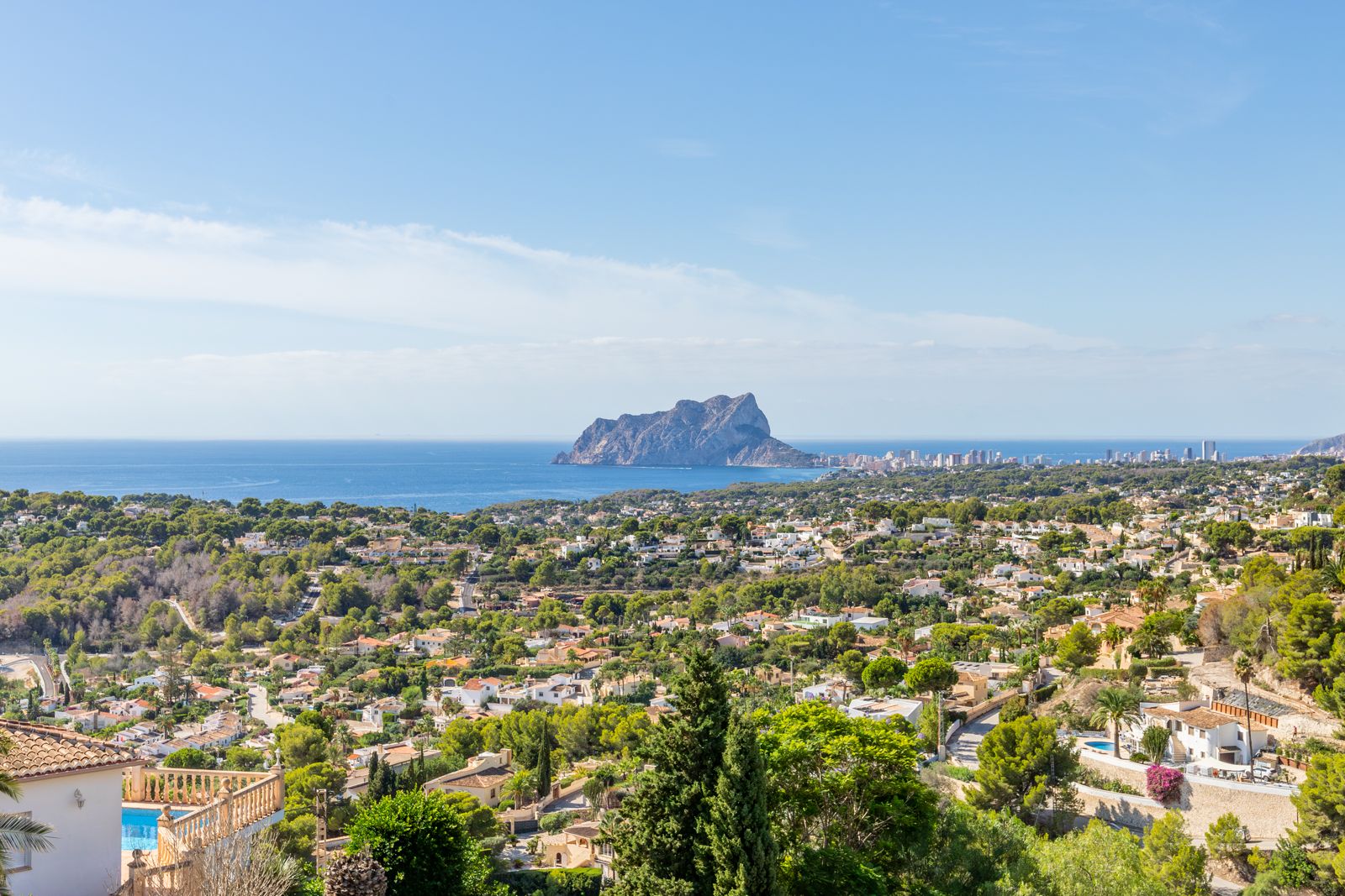 Panoramisch uitzicht vanaf de woning op de Peñón de Ifach en de Middellandse Zee, omgeven door het weelderige groen van Benimeit in Moraira.