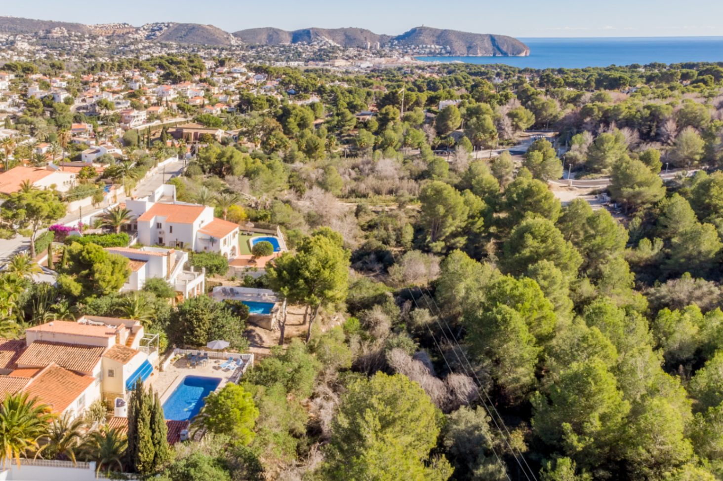 Luchtfoto die de bevoorrechte locatie naast een beschermd natuurgebied benadrukt, met panoramisch uitzicht op de Middellandse Zee en de kust van Moraira.