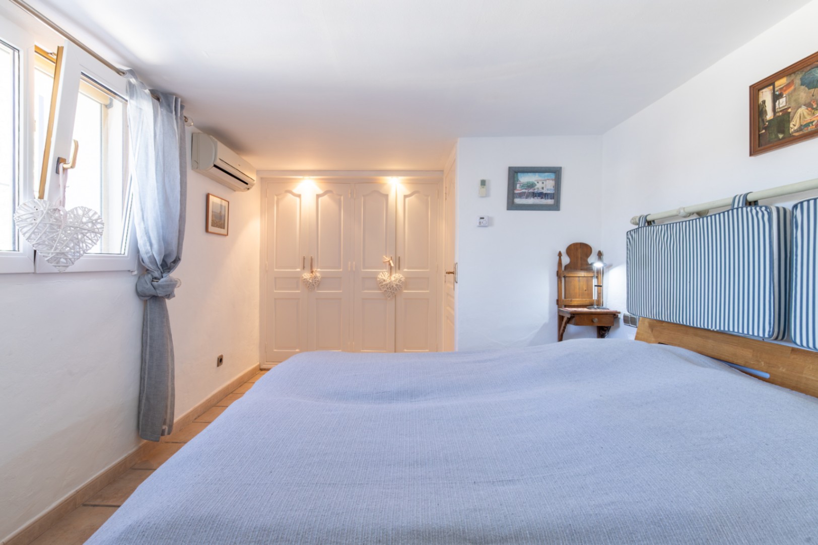 Slaapkamer met witte inbouwkasten, geïntegreerde verlichting, airconditioning en dubbele beglazing voor een rustige en comfortabele sfeer.