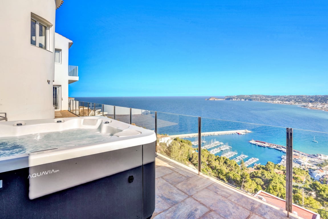 Aquavia Spa buitenjacuzzi op een terras met stenen vloer en glazen balustrades, met panoramisch uitzicht op de haven van Jávea en de Middellandse Zee.