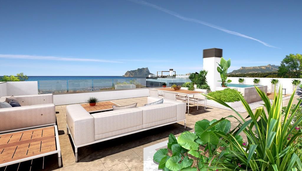 Dakterras met loungehoek, eethoek buiten en glazen balustrades met panoramisch uitzicht op de Middellandse Zee en de Peñón de Ifach.