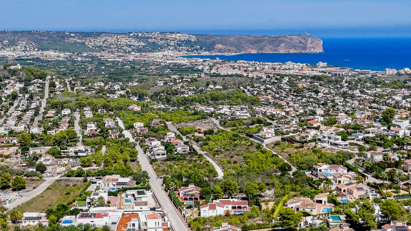 Panoramisch luchtfoto van Jávea met uitzicht op de Middellandse Zee, Cabo de San Antonio en de woonwijken te midden van het mediterrane groen.