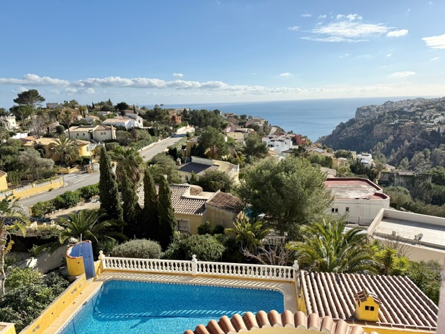 Verhoogd uitzicht op het privézwembad en de mediterrane tuin, met een panoramisch zicht over de kustlijn en de zee in Benitachell.
