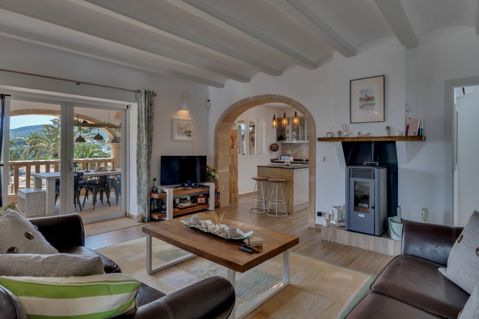 Lichte woonkamer met moderne open haard en toegang tot terras met uitzicht.
