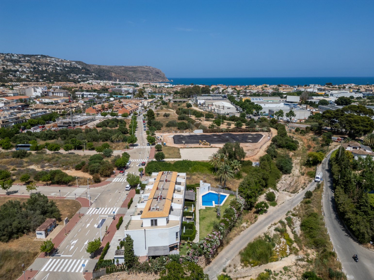 Luchtfoto van het moderne wooncomplex in Jávea, met het gemeenschappelijke zwembad en de gunstige ligging nabij de kust en het historische centrum.