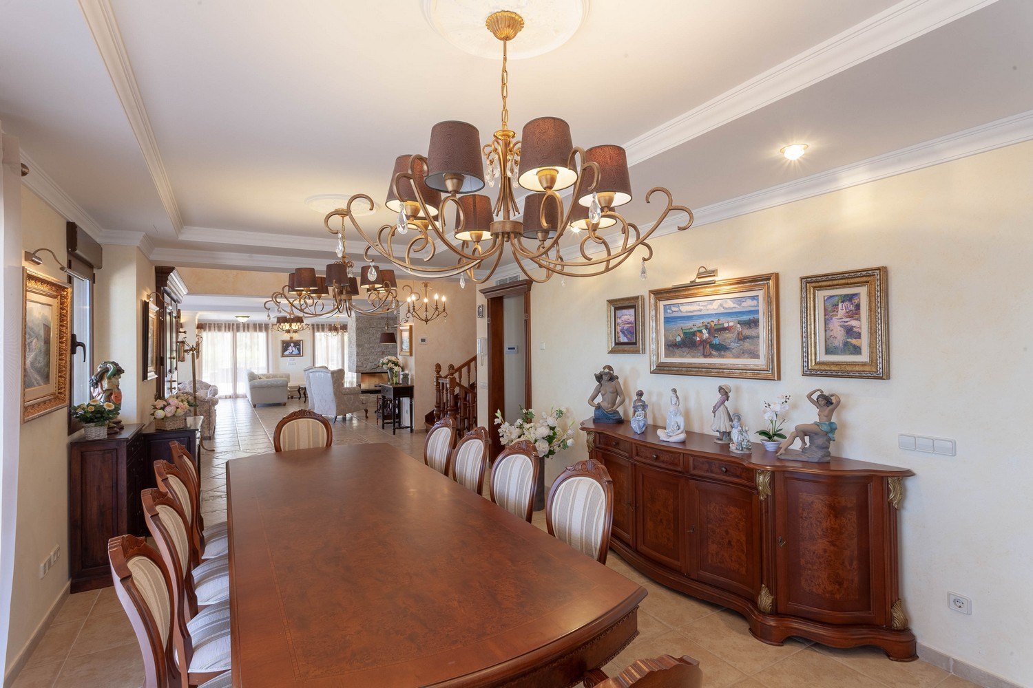 Formele eetkamer met donkerhouten tafel, gestoffeerde stoelen en klassiek dressoir met gouden accenten.