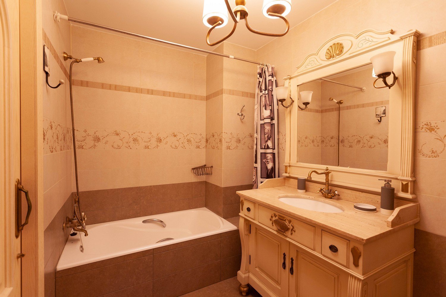 Klassieke badkamer met ligbad, wastafel met marmeren blad en sierlijke spiegel.